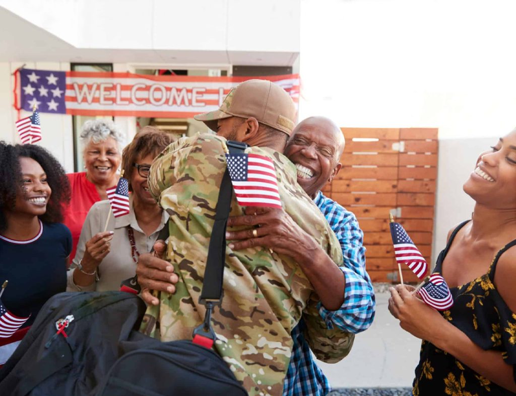 Soldier being embraced and welcomed home by loved ones