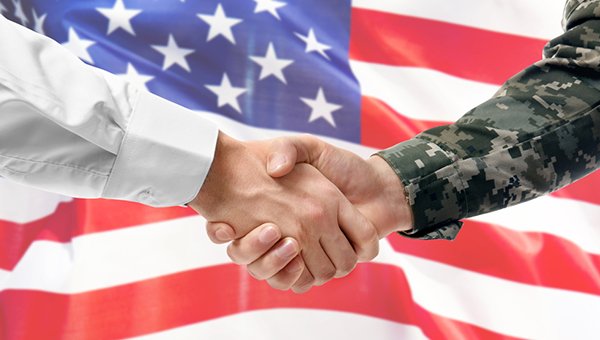 Military person shaking hands with business professional